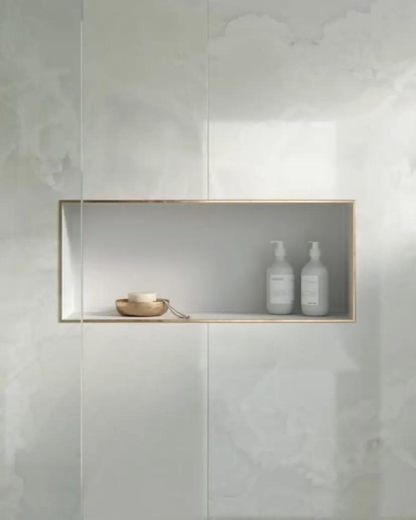 Grapevine bathroom remodel idea: groutless Dekton shower wall with a long brass-trimmed niche