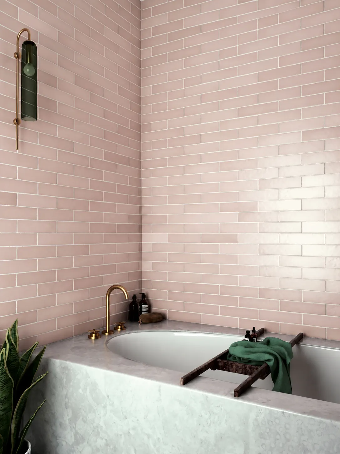 Soaking tub with a marble surround, blush pink tile and a brass wall faucet