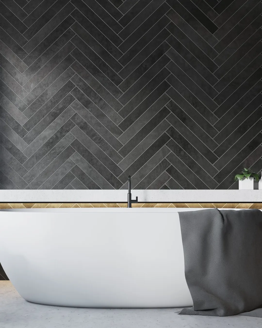 White freestanding tub in front of a charcoal herringbone tile wall with a lit ledge