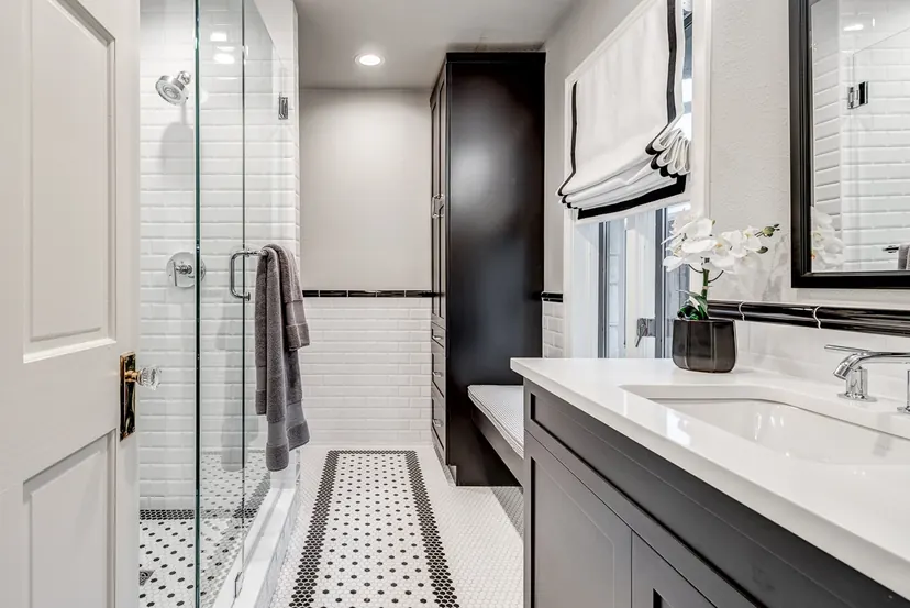 McKinney bathroom remodel idea: glass walk-in shower, subway tile with a black liner and a dark vanity