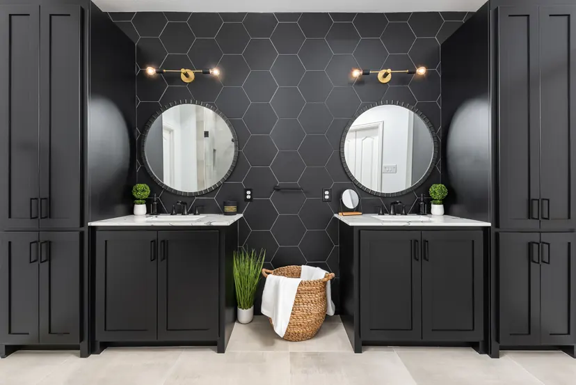 Prosper bathroom remodel idea: black double vanity, round mirrors and a black hexagon tile wall